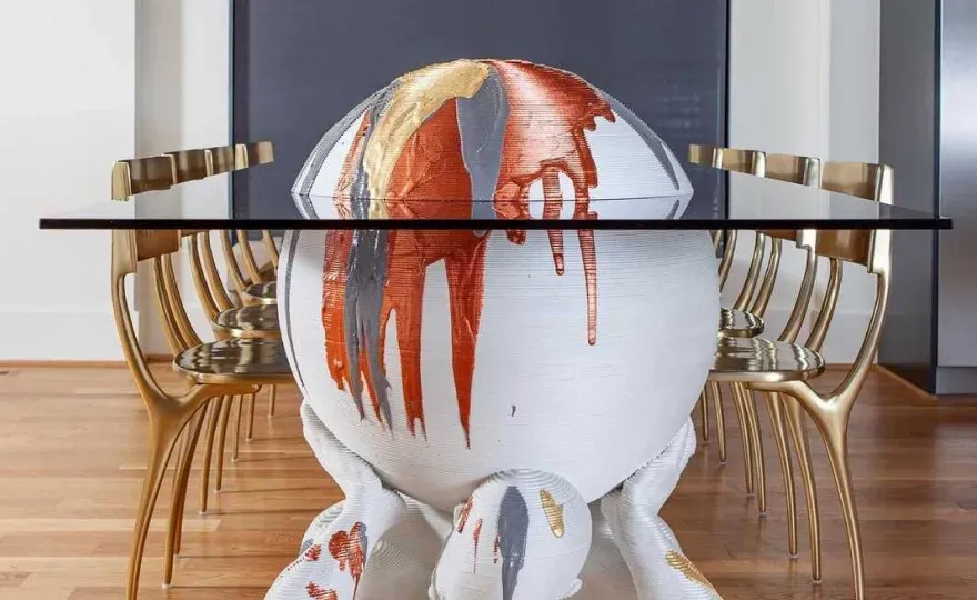 Custom glass tabletop with a unique artistic base, showcasing creativity and design, surrounded by contemporary chairs.