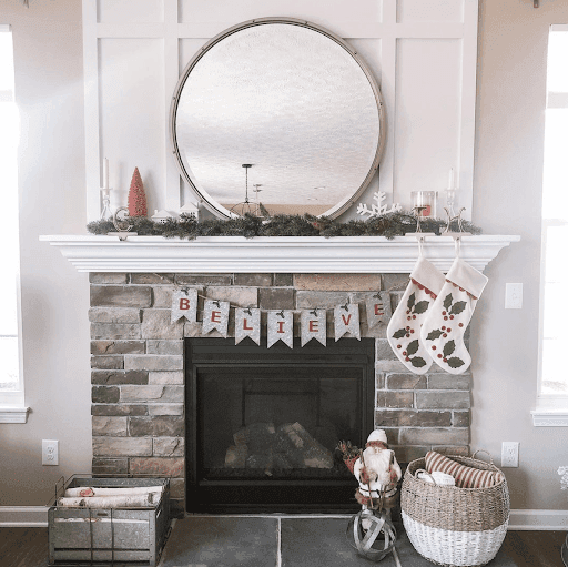 Custom beveled glass mirror above a stone fireplace decorated for the holidays