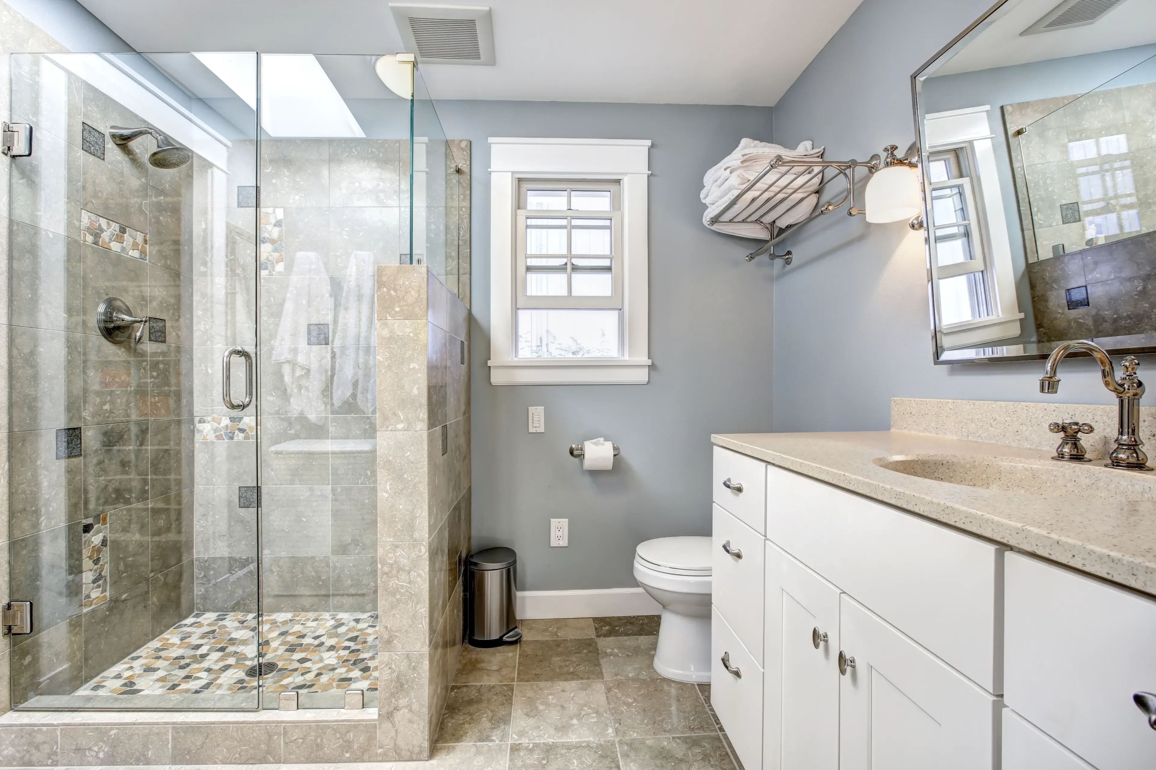 Contemporary bathroom featuring custom glass shower doors, a sleek countertop, decorative tile, and a framed mirror, showcasing tempered glass design.