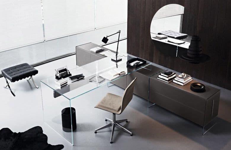 Modern glass desk with custom glass table tops, accented by a beveled glass edge mirror, showcasing elegant office decor and stylish design elements.