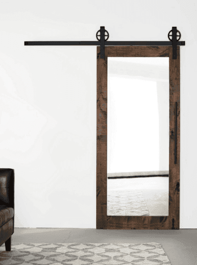 Sliding barn door mirror with a wooden frame and black hardware