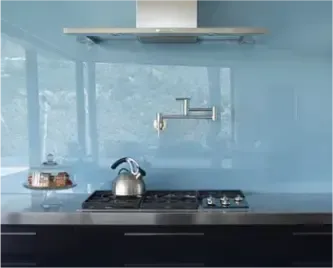 Custom glass backsplash in a modern kitchen showcasing a sleek design with tempered glass surfaces, complementing shower doors, table tops, and beveled glass edges.