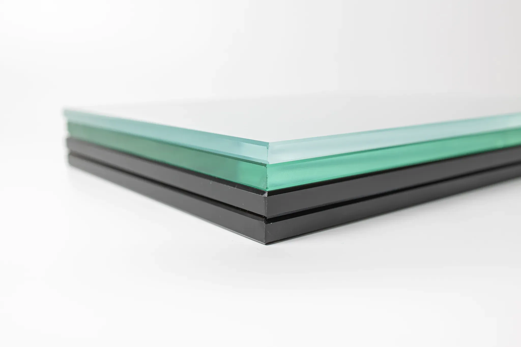 Stacked pieces of custom glass featuring tempered glass and beveled glass edge, suitable for shower doors, table tops, and mirrors.