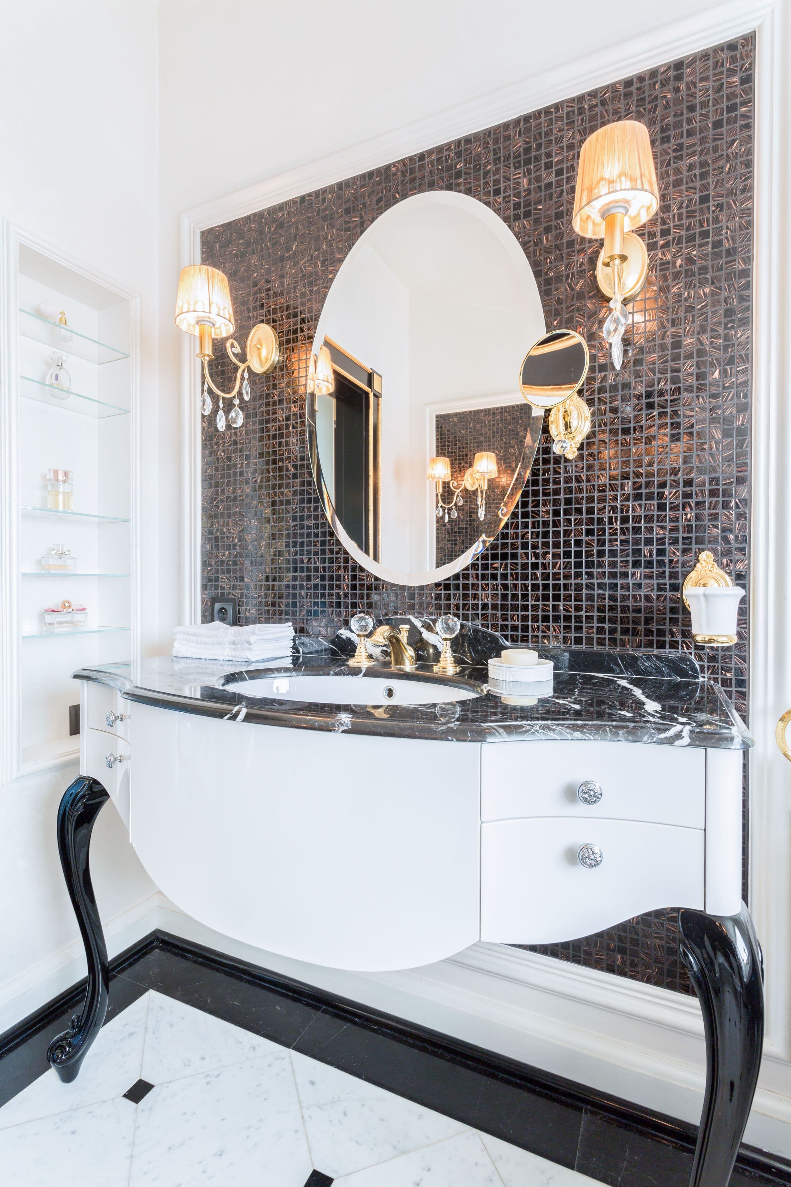 Elegant bathroom featuring a custom beveled glass mirror, sleek black stone countertop, and stylish lighting, showcasing luxury design elements for shower doors and custom glass solutions.