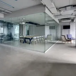 Modern office space featuring custom glass walls, showcasing tempered glass for enhanced design and functionality, ideal for shower doors, table tops, and mirrors.