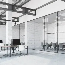 Modern office space featuring custom glass walls, showcasing a sleek design with tempered glass partitions, enhancing natural light and transparency.