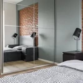 Custom glass mirror with a beveled edge reflecting a modern bedroom, showcasing stylish design and functionality for shower doors and table tops.