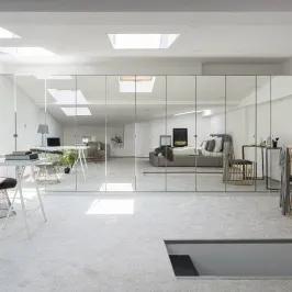 Modern living space featuring custom mirrors and tempered glass design elements, showcasing the versatility of glass for shower doors and table tops.