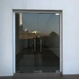 Modern glass entrance featuring custom shower doors made of tempered glass, showcasing sleek design with beveled glass edge for a contemporary look.