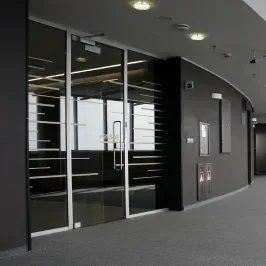 Modern glass entry doors with sleek lines, ideal for custom glass solutions in commercial spaces, showcasing tempered glass craftsmanship.