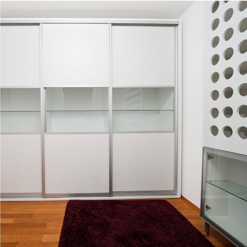 White closet with glass doors and shelves for storage