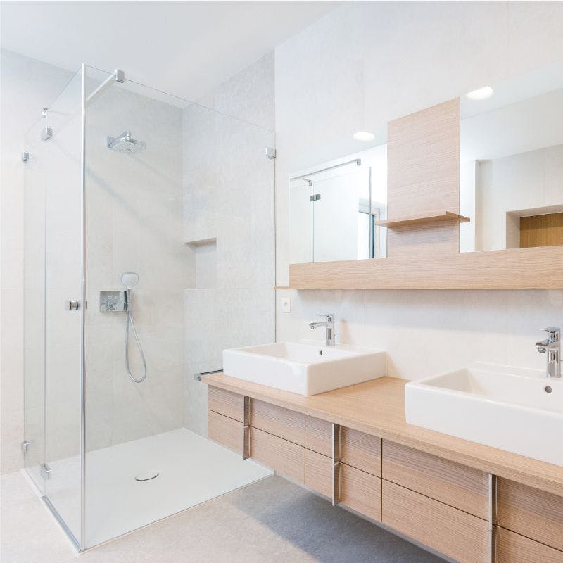 Contemporary bathroom with dual sinks, mirrors and a sleek shower