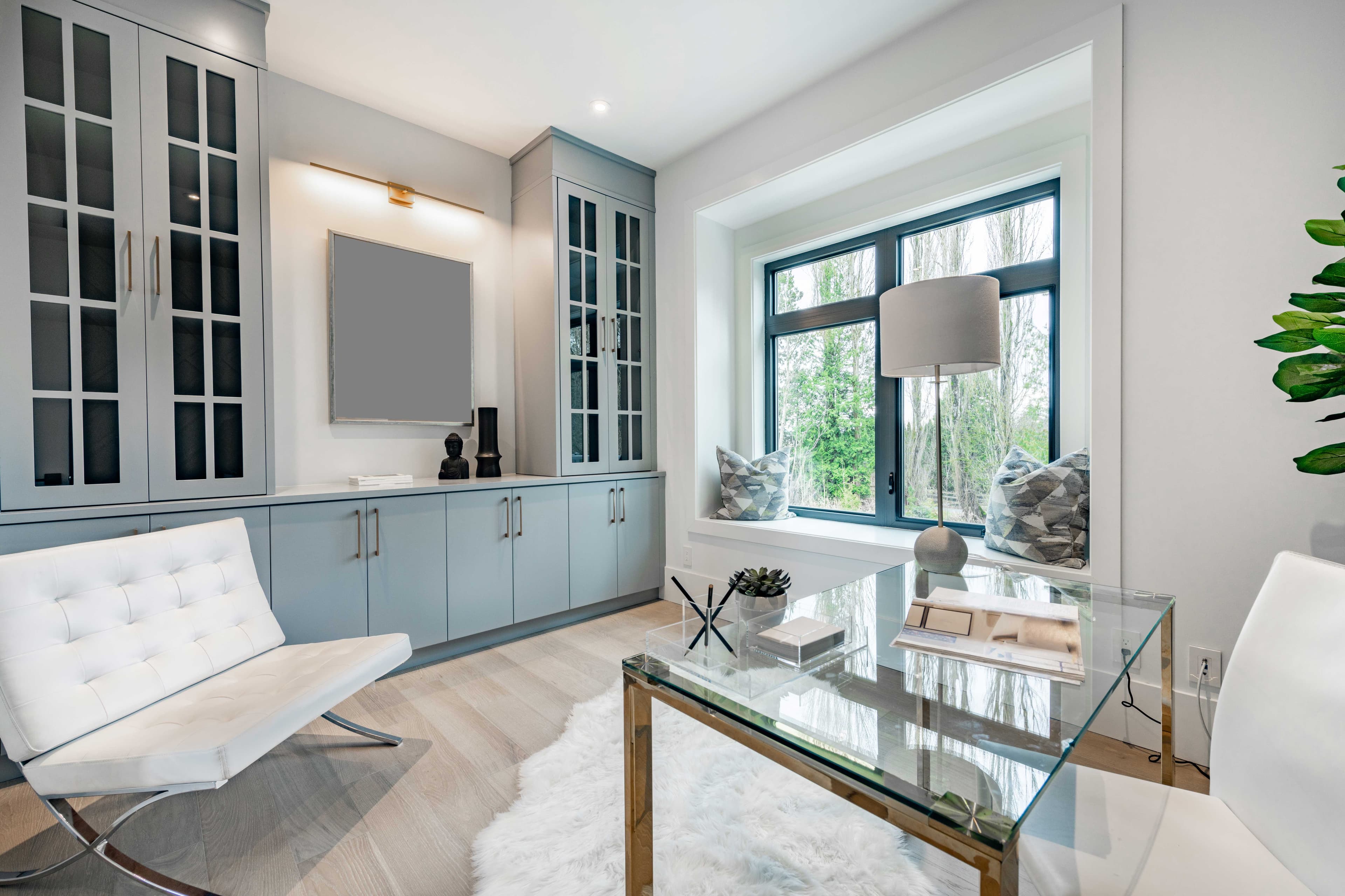 Modern interior featuring a glass table top, custom storage cabinets, and a mirror, showcasing stylish design elements relevant to shower doors, tempered glass, and beveled glass edge.