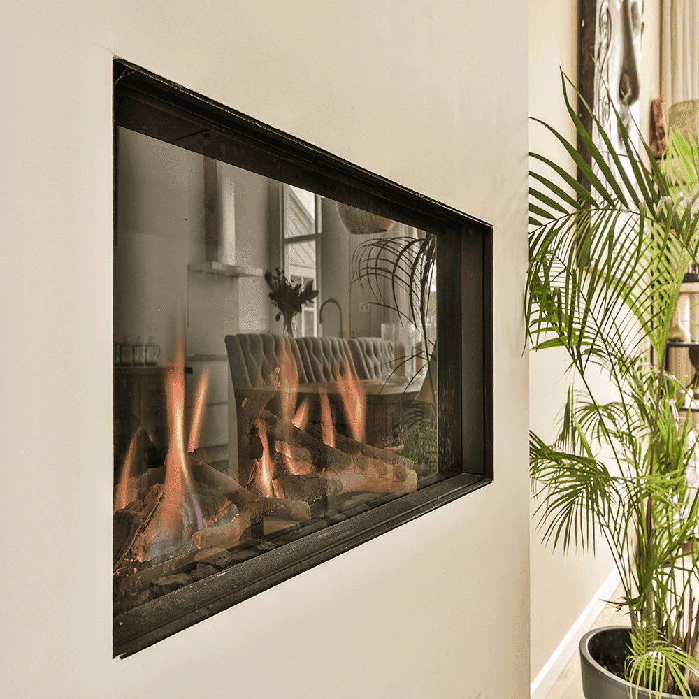 Modern fireplace with custom glass surround, showcasing tempered glass for safety and style, enhancing the living space's aesthetic appeal.