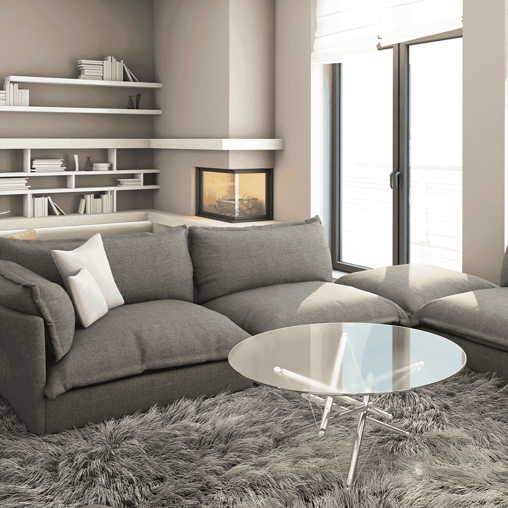 Modern living room featuring a stylish glass coffee table, showcasing custom glass design, complemented by plush gray seating and a warm fireplace.