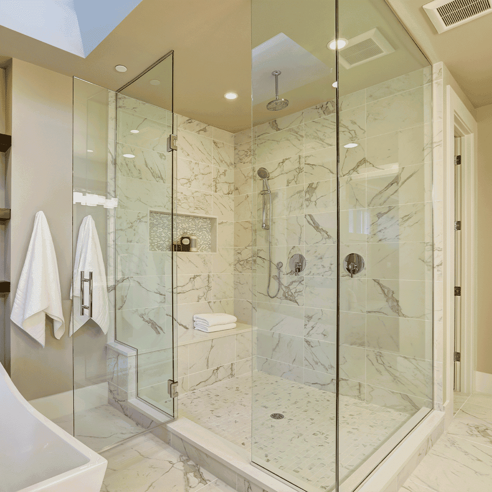 Custom glass shower doors featuring sleek tempered glass in a modern bathroom with marble tile accents, showcasing a luxurious design.