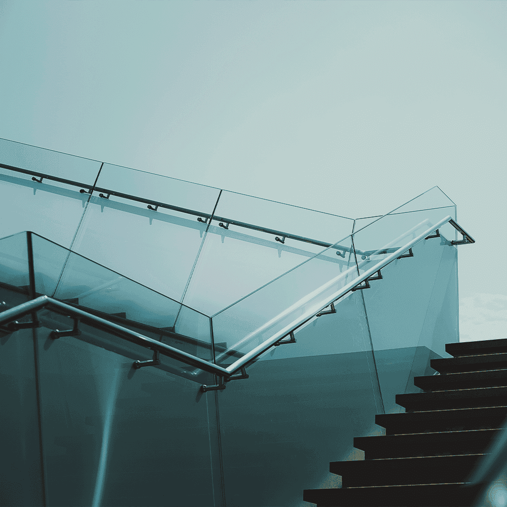 Stylish glass railing on stairs with a focus on custom glass, tempered glass, and modern design elements.