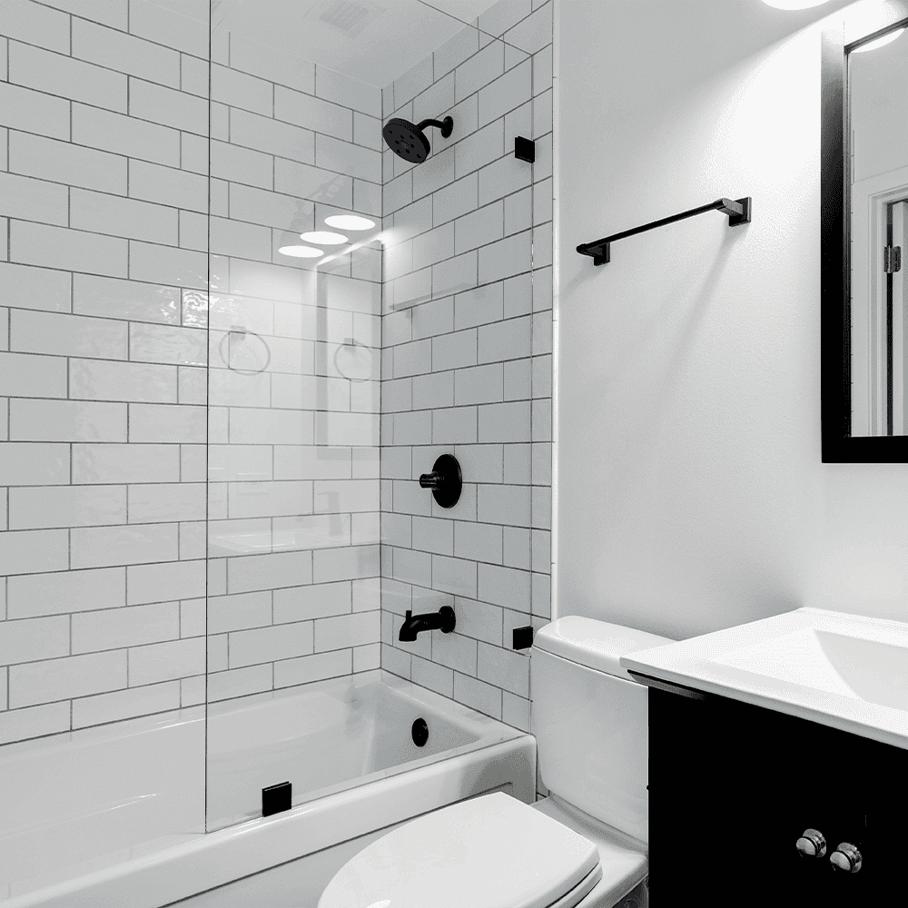 Clear tempered glass shower door in modern bathroom with white subway tile