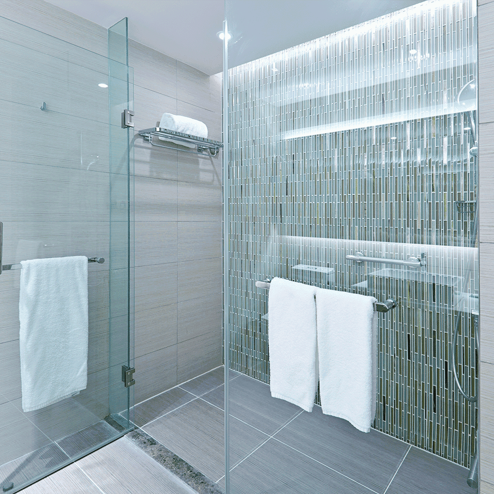 Modern shower design featuring frameless shower doors and custom tempered glass