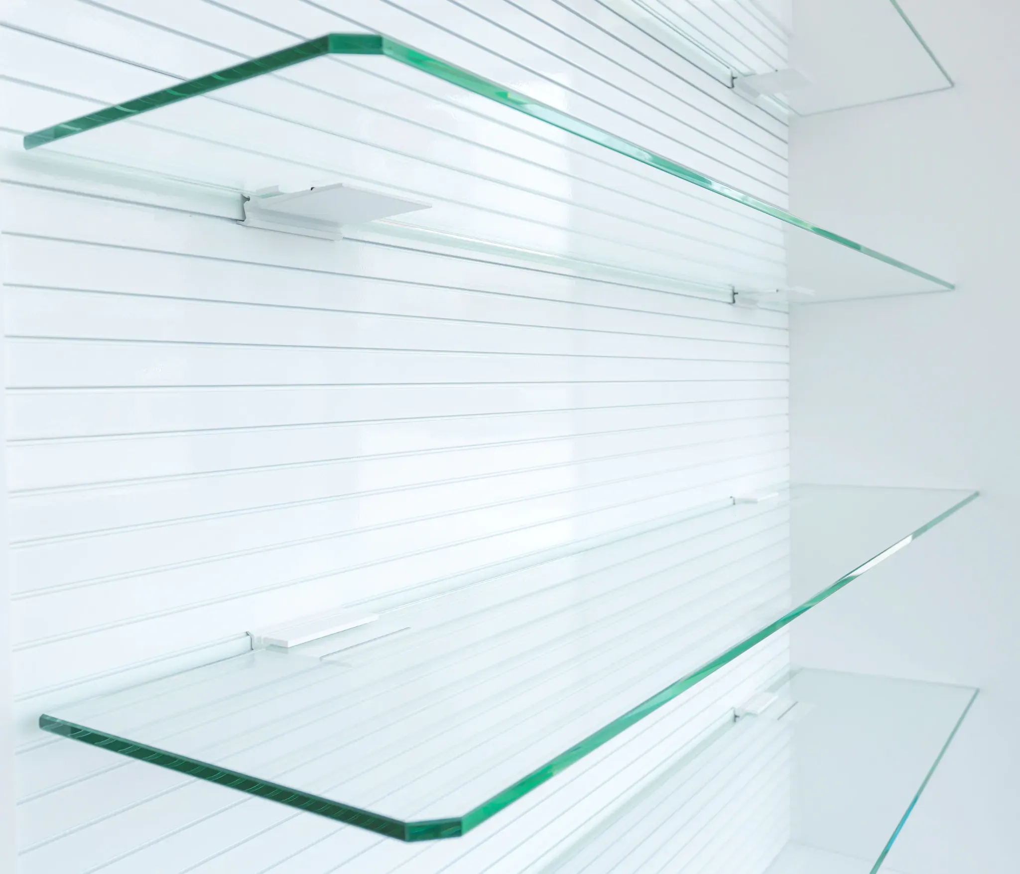 Custom glass shelves displaying tempered glass with a sleek design, ideal for shower doors, table tops, and mirrors, featuring a clean beveled glass edge.