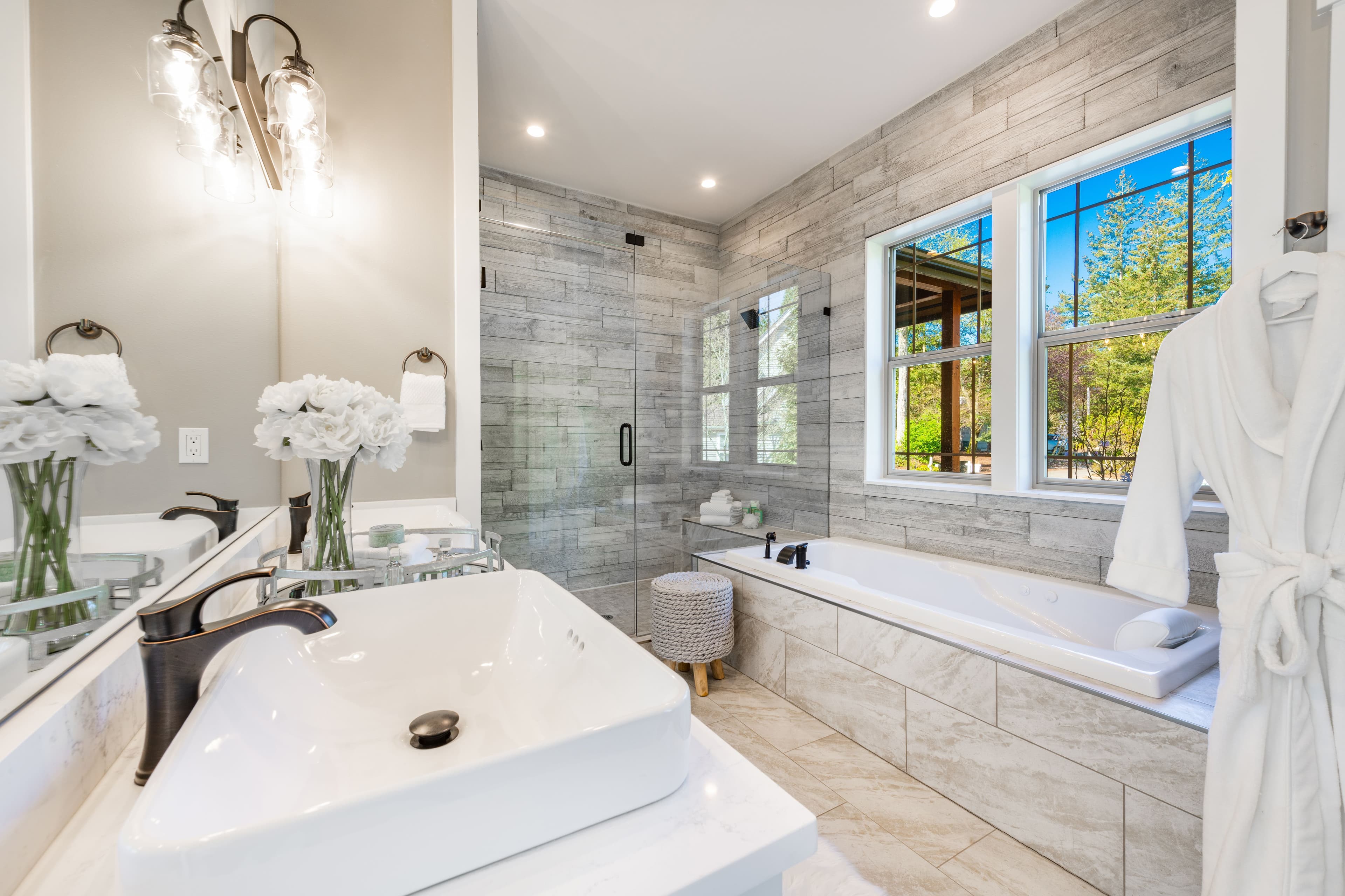 Modern bathroom showcasing custom glass shower doors, a stylish beveled glass mirror, and elegant dÚcor, highlighting tempered glass elements and functional design.