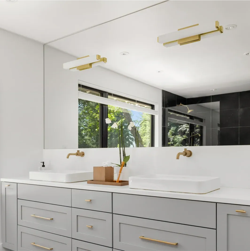 Modern bathroom featuring custom mirrors, sleek design, and tempered glass elements, including shower doors and beveled glass edges, complemented by elegant fixtures.